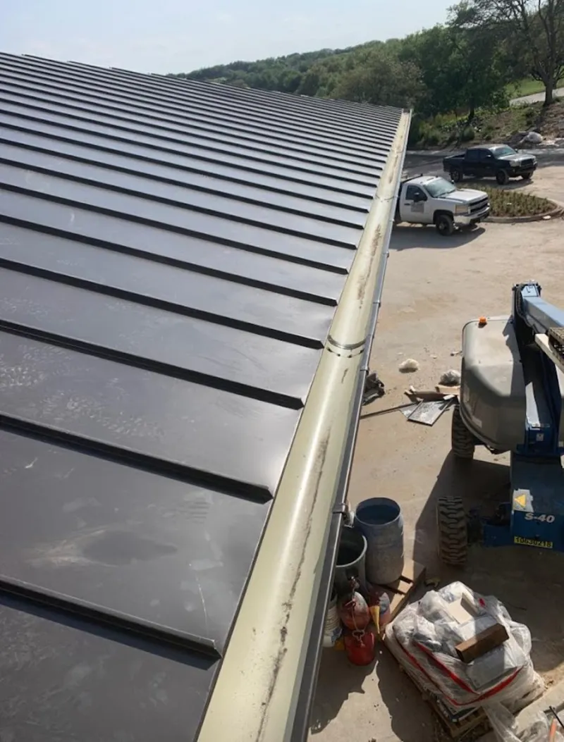 Standing seam panel and gutter detail on a metal roofing jobsite in Evansville